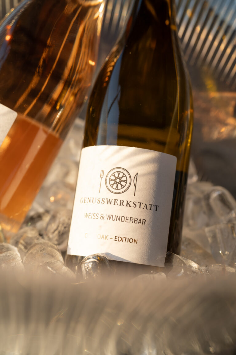 Flasche der Genusswerkstatt im Eis neben weiteren Getränkeflaschen