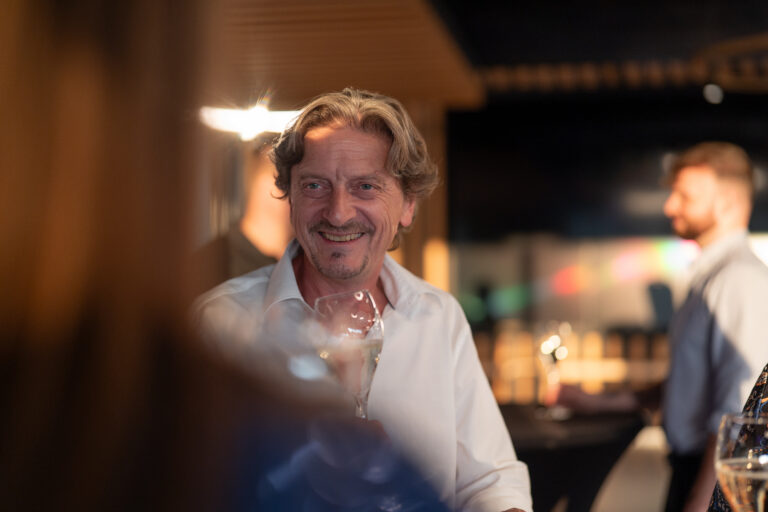 Gast mit Weinglas bei einer Veranstaltung der Genusswerkstatt